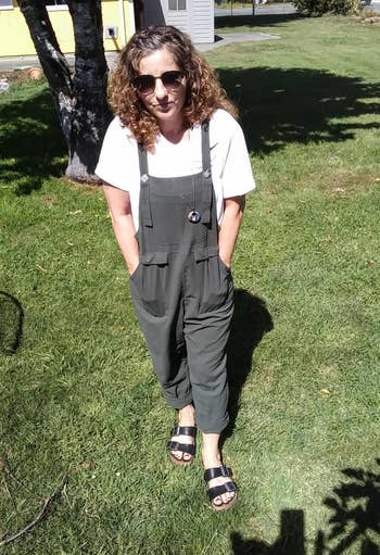reviewer in olive overalls with their hands in the pockets