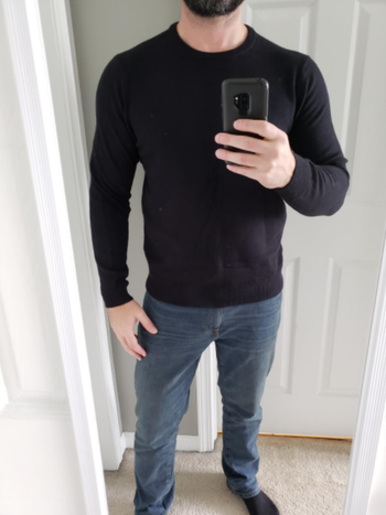 reviewer taking a selfie while wearing the crewneck in black