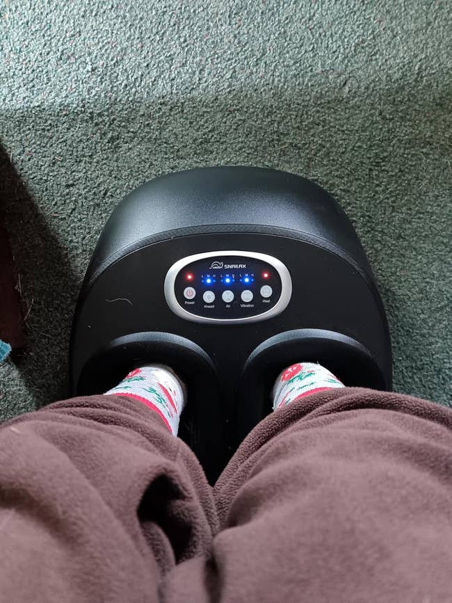 Person utilizing a ft  massager with LED display, wearing cozy socks