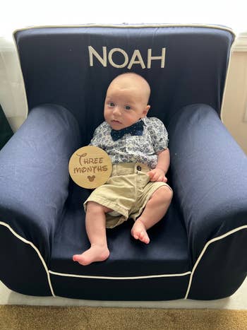 editor's son sitting in a blue child-sized chair with white trim