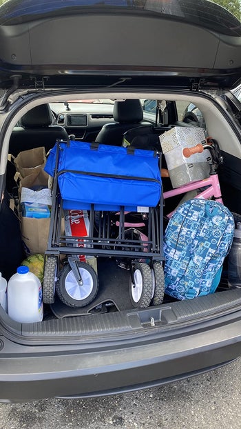 reviewer showing how the wagon folds up small to fit in the trunk of a car