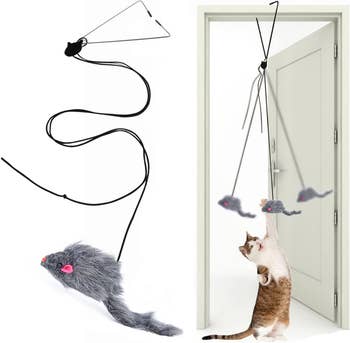 Cat playing with a door-hanging mouse toy, demonstrating the product's use for indoor pet amusement