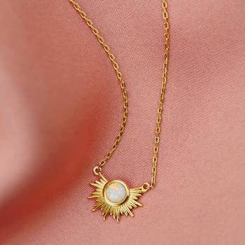 necklace with small opal surrounded by gold sunburst design