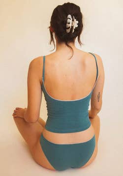 Model wearing the teal blue cami showing the deep scoop back 