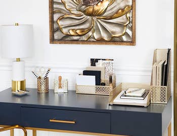a desk with gold organizer accessories on it