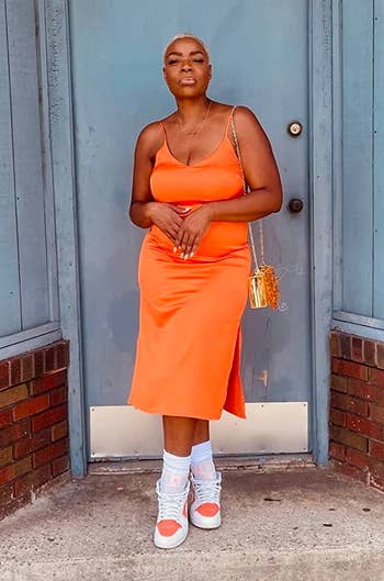 reviewer wearing the dress in orange