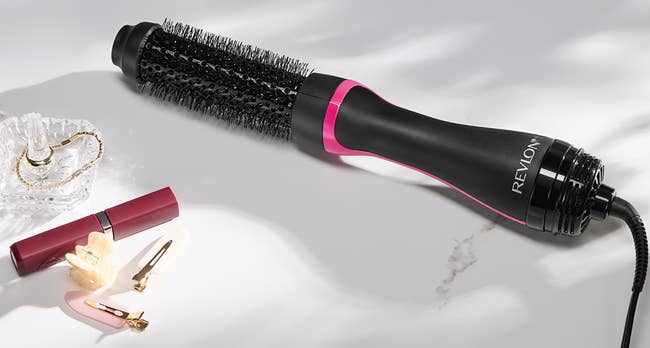 Revlon blistery aerial brushwood with 3 heating options for styling, surrounded by decorative items, promoting brushed curls and volume