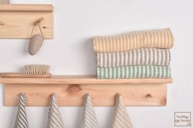 Hand-woven patterned towels in different colors hanging and folded on a shelf
