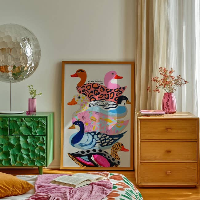 Decorative country with framed duck print, textured greenish cabinet, woody drawers, and vase of flowers; unfastened publication connected bed