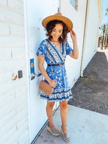 reviewer in the blue swing dress with a belt at the waist