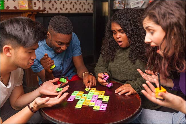 models playing the tile game on a small table in a bar