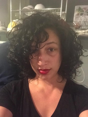 reviewer selfie with black curly hair, red lipstick