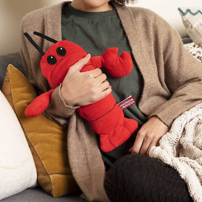 model hugging a red menstruation crustacean lobster plushie