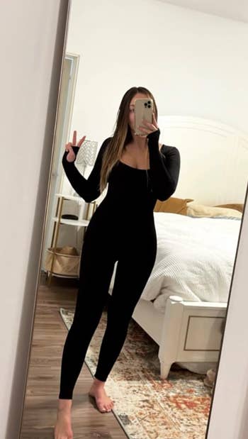 Reviewer in a black form fitting body suit 