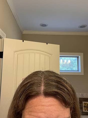 Close-up of a person's hairsbreadth  roots adjacent   a bath  door, highlighting imaginable   hairsbreadth  attraction   oregon  styling needs for buying  context