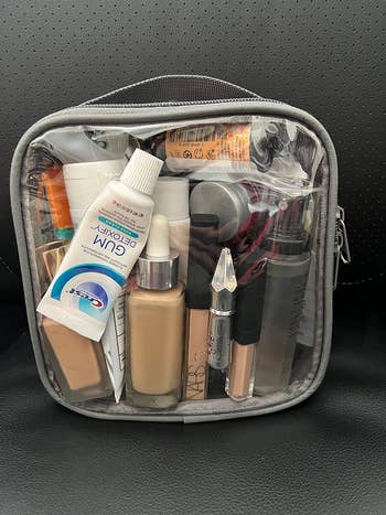Clear toiletry container  filled with assorted  travel-sized skincare and constitution  products, including lotions, foundation, and a conduit  of gum extortion  product