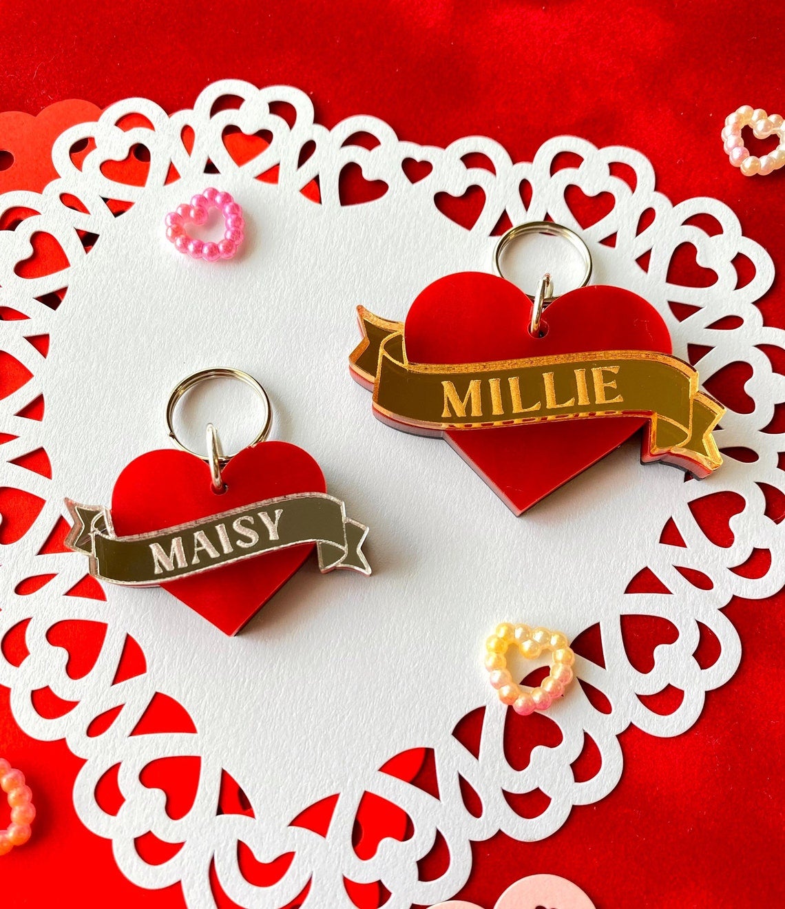 acrylic charms that look like the classic heart tattoos with the banners that say mom but in this case they said maisy and millie