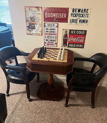 a reviewer photo of a chess table with the chairs on black on either side 