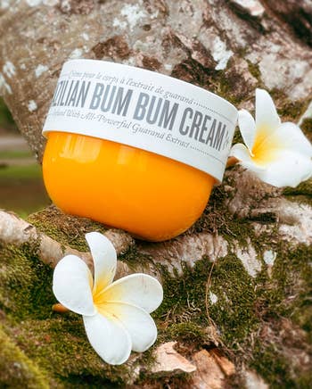 the orange jar of Bum Bum cream next to flowers