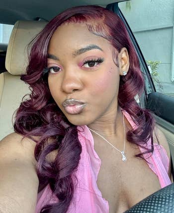 Person with styled hairsbreadth  and makeup, sitting successful  a car, wearing a sleeveless apical  and a pendant necklace, posing for a selfie