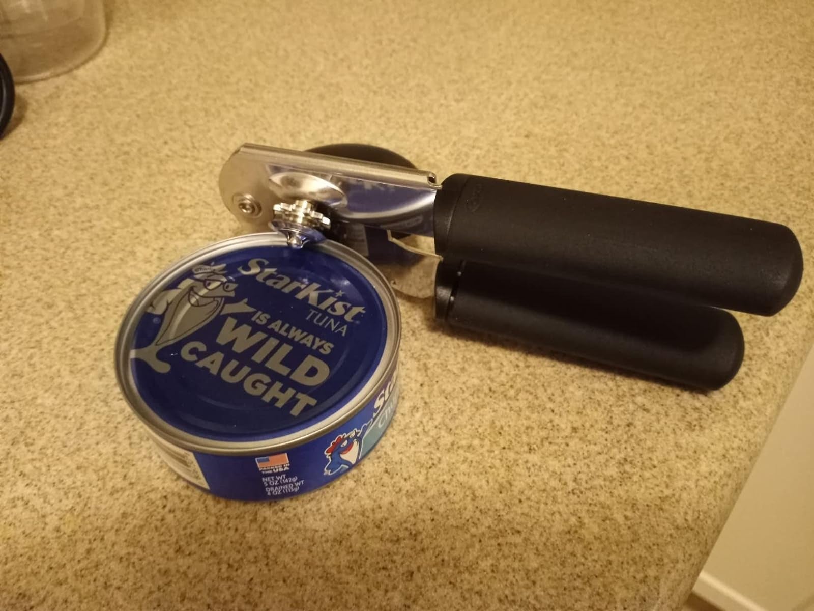 a reviewer's can opener on a can of tuna