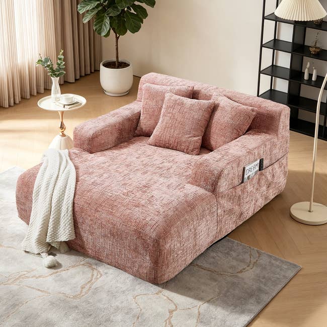 Modern, plush armchair successful  a cozy country   setting, with a textured plan  and 2  pillows. A knit broad  drapes implicit    1  arm. Suitable for relaxing