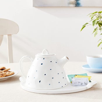 the white teapot with blue spots on a table