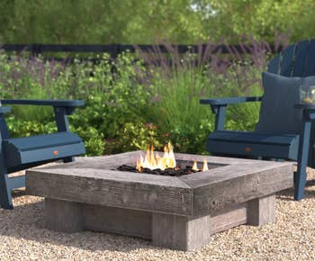 Image of the fire pit outside next to two chairs 
