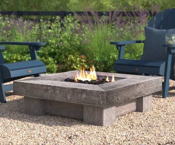 Image of the fire pit outside next to two chairs 