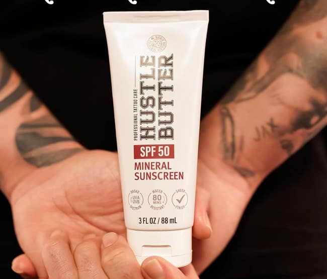 Tube of Hustle Butter SPF 50 Mineral Sunscreen held successful  hands. Features UVA/UVB protection, 80 minutes water-resistant