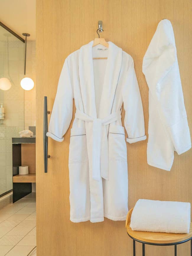 white robe with grey piping on a hanger