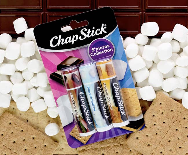 The ChapStick S'mores Collection with real s'mores in the background