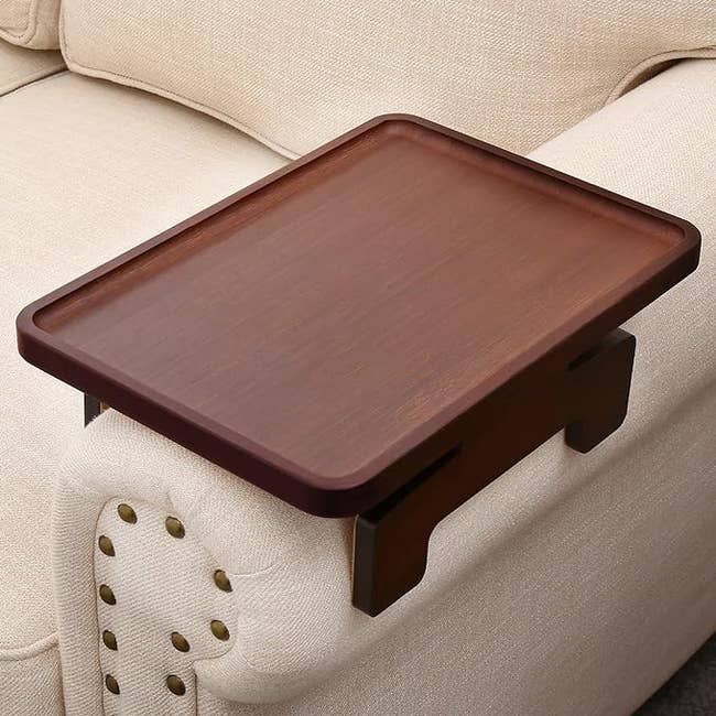 wooden walnut tray on the arm of a sofa