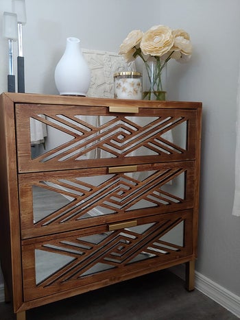 reviewer photo of mirrored small dresser with vases on top