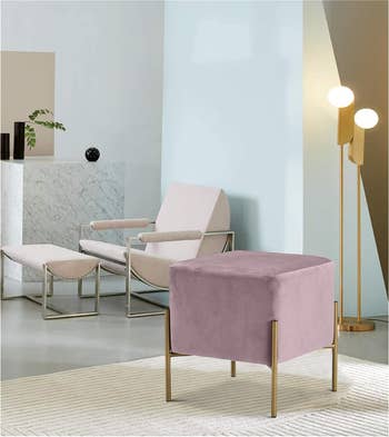 Minimalist living room with a modern chair, an ottoman, and sleek floor lamp