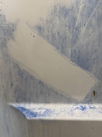 Abstract pattern with textured white and blue markings on a surface, resembling a weathered or artistic effect