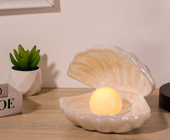 Pearlescent shell-shaped lamp with a glowing pearl inside 