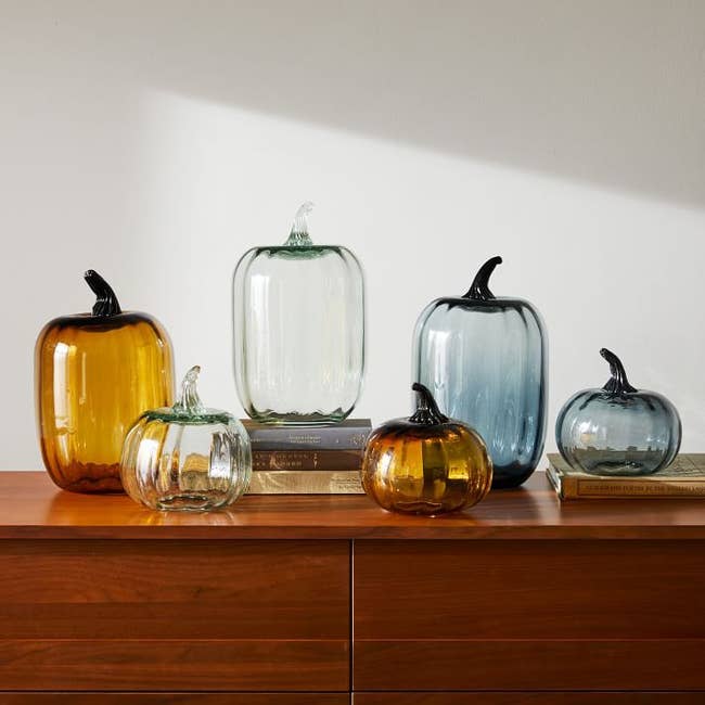 several glass pumpkins in varying shapes and sizes on a table 