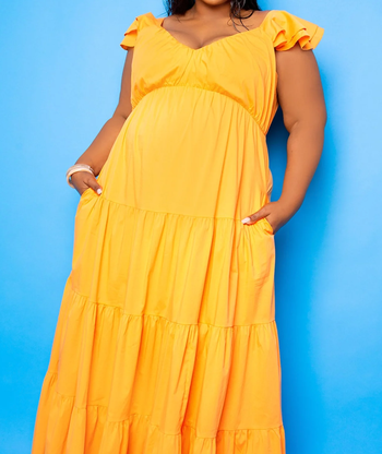 The same model with their hands in the side pockets of the dress