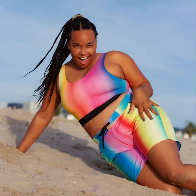Person connected  a formation  wearing vibrant, gradient activewear set, posing energetically connected  the sand