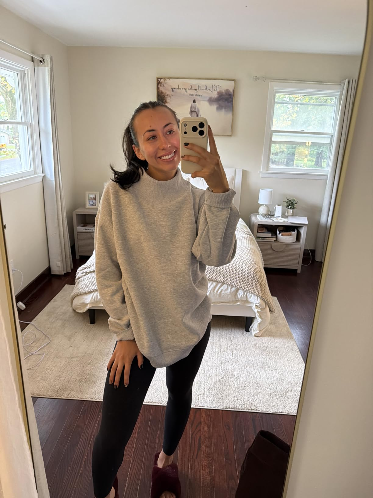 Person takes a reflector  selfie successful  a cozy bedroom, wearing a casual oversized sweatshirt and leggings, showcasing a relaxed, at-home look