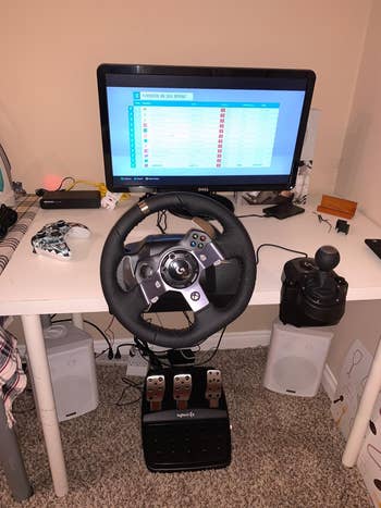A gaming setup with a racing wheel, pedals, and a show   displaying a racing crippled  leaderboard. Ideal for racing crippled  enthusiasts