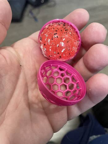 reviewer photo of the pink sticky ball covered in dirt, hair, and crumbs
