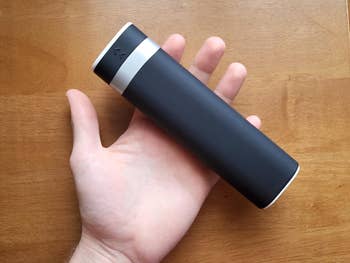 same reviewer holding the closed black pill organizer