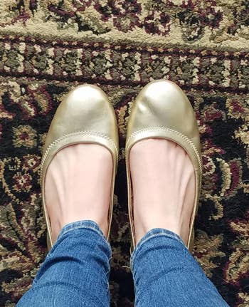 reviewer wearing the gold flats