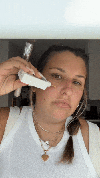 buzzfeed writer Ali applying skin tint to one half of face