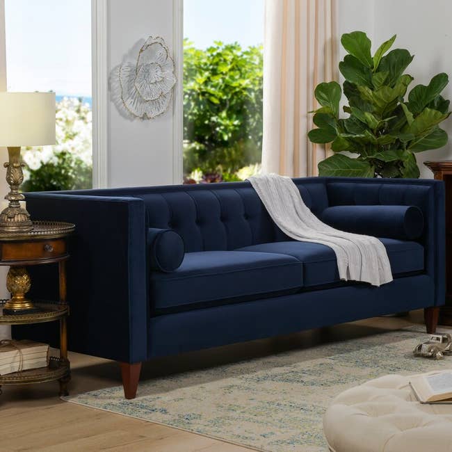 The dark blue velvet sofa in a living room 