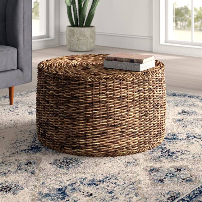 Image of the brown rattan/wicker coffee table with books on it