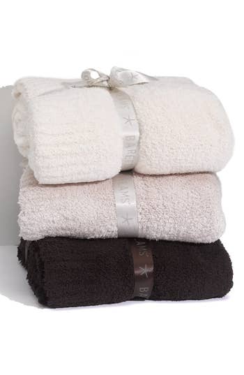 Three stacked plush towels with decorative ribbons, ideal for elegant bathroom decor