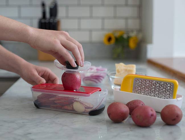 hand grating a red potato using the slicer plate